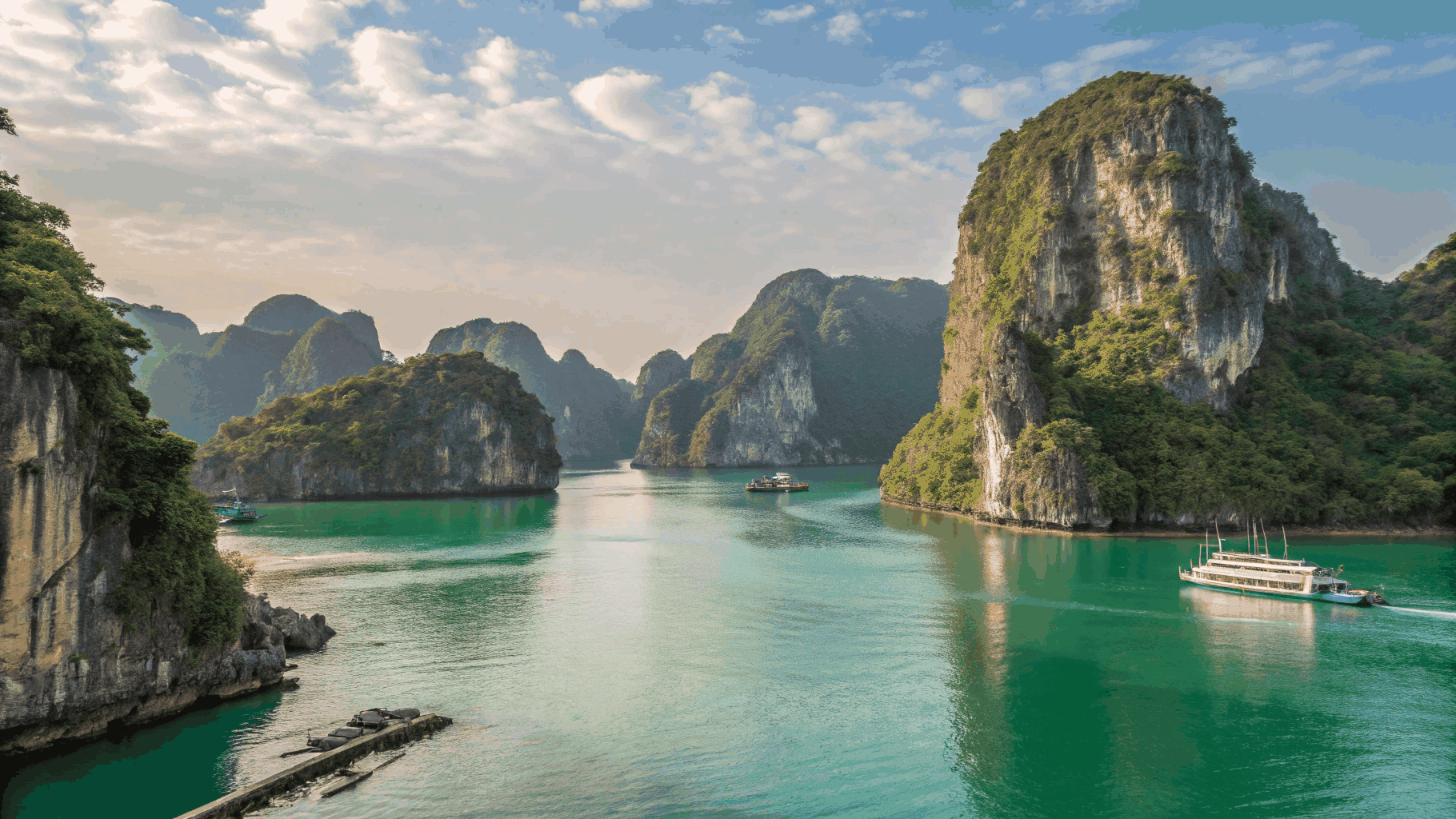 Ha Long Bay limestone islands at dusk and cruise boat
